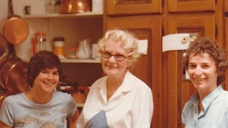 Simone Beck wearing glasses standing with students