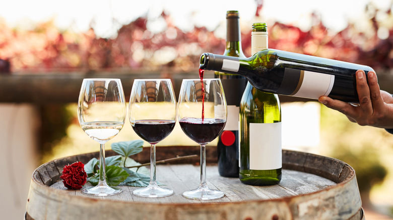 Wine poured into glasses on barrel 