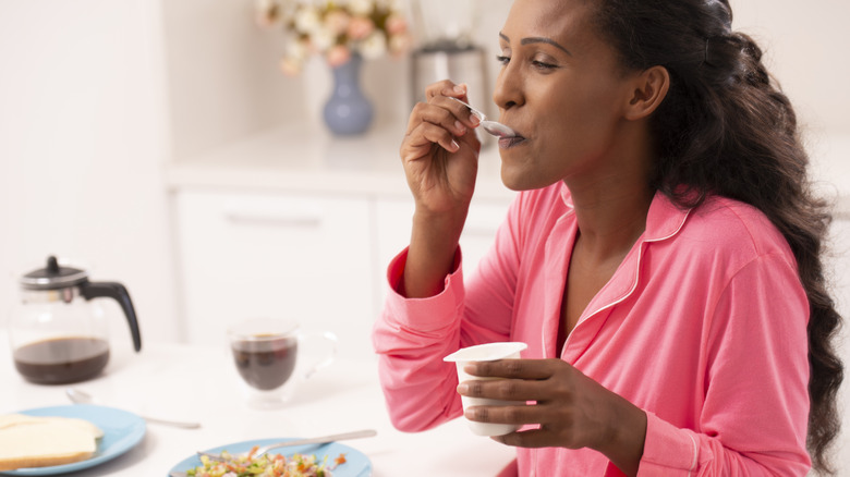 woman eating yogurt cup