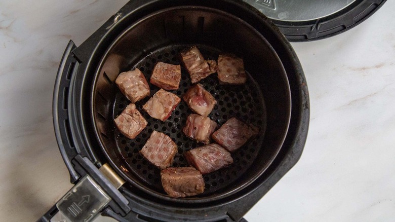 Steak cubes in air fryer basket