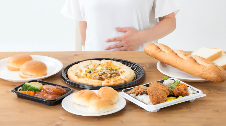 woman full, with a table full of food