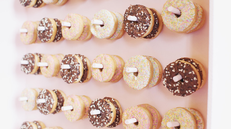 A doughnut wall with a mixture of chocolate-frosted and vanilla-frosted doughnuts on it