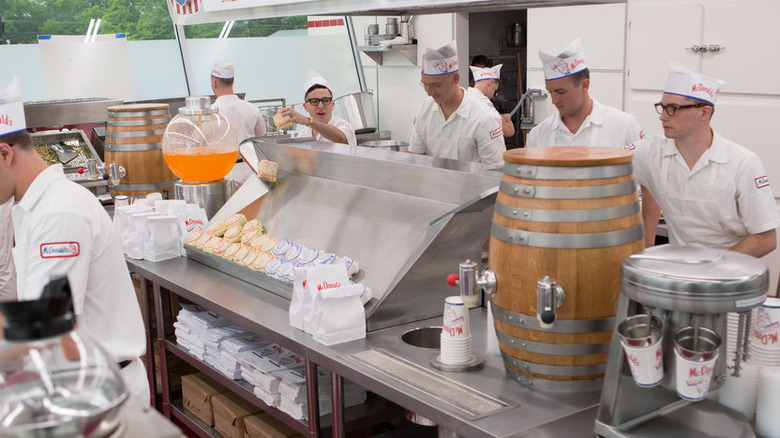 A still image from the movie, The Founder. McDonald's employees in all white with paper hats.