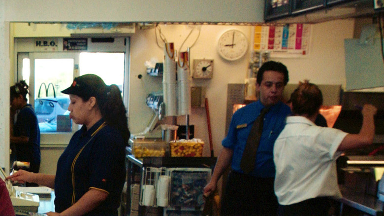 Various McDonald's employees in red polos and a manager in a blue button up with a red tie.