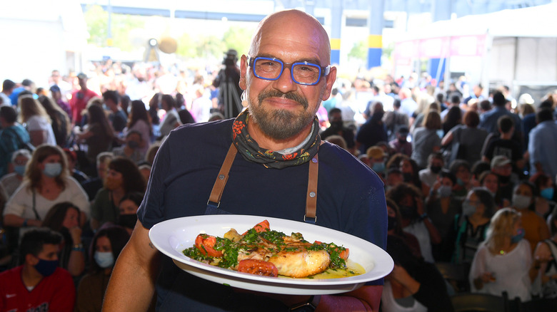 Michael Symon holds plate of food