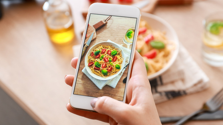 Person photographing food with smartphone