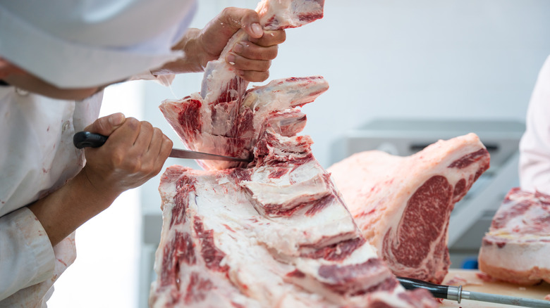 Butcher cutting bone from meat 