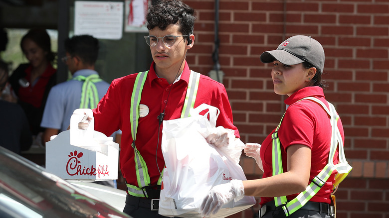 Chick-fil-A employees serving food at drive-thru