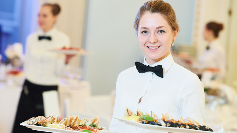 Smartly dressed waiter with black bow tie