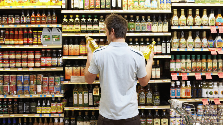 A shopper comparing options in a grocery aisle