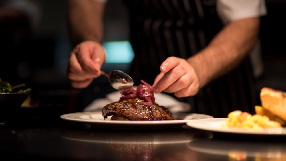 Chef plating a steak