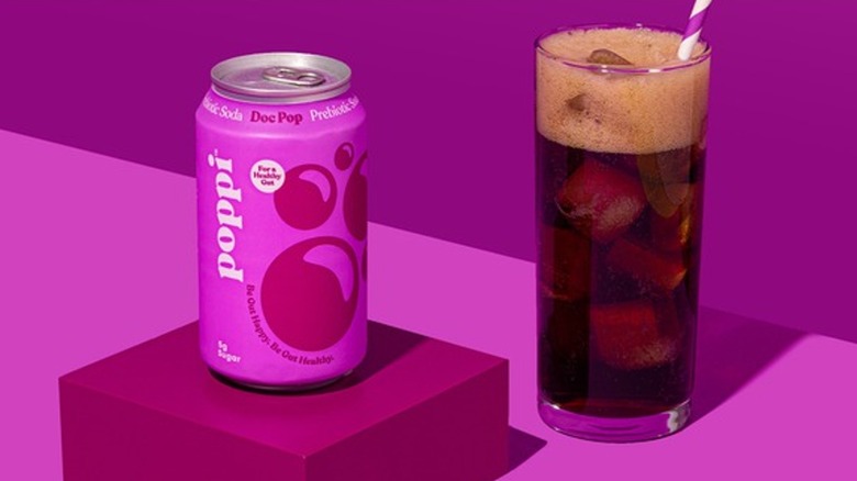 A can of Poppi next to a poured glass of the soda