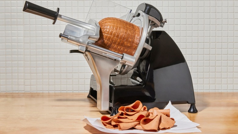 Prime Roots meat on meat slicer with sliced meat in foreground.