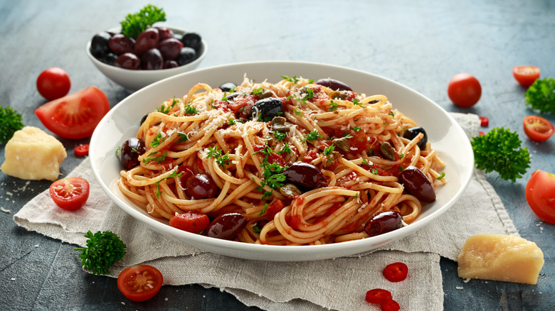 Popular Italian spaghetti dish in bowl with olives