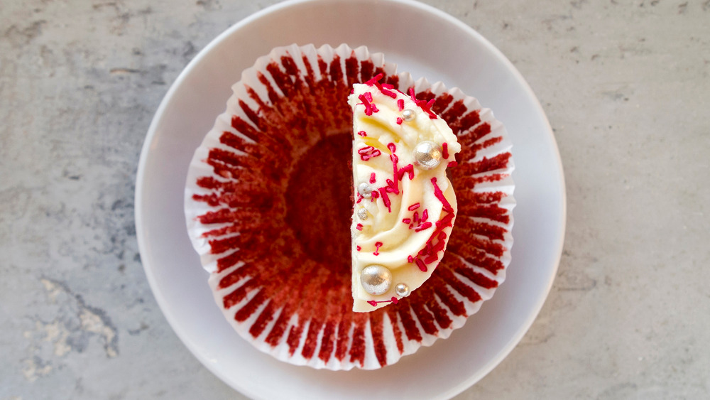 half of a red velvet cupcake on a saucer