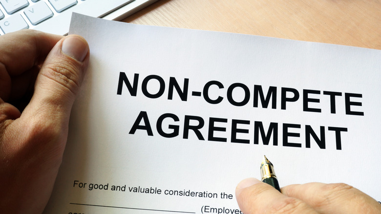 hands holding a non-compete agreement form