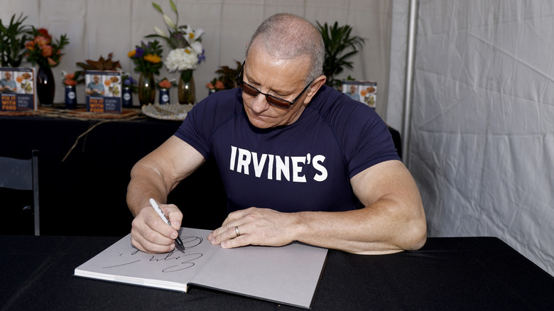 Robert Irvine signing a piece of paper