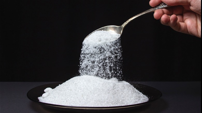 Salt pouring from spoon onto plate