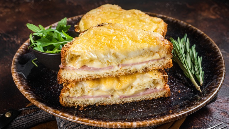 Croque Monsieur with rosemary on a black plate 