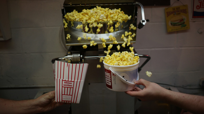 Employee filling popcorn buckets