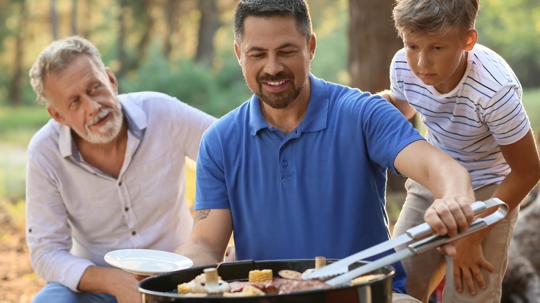 three male generations grilling outside