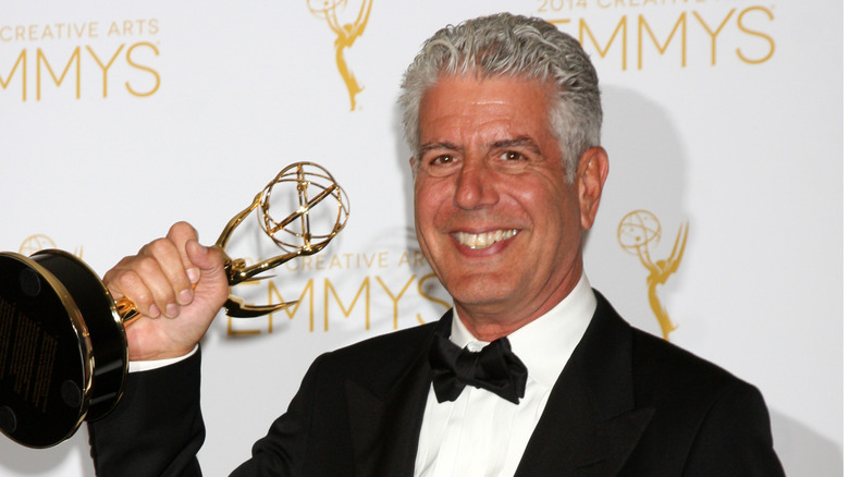 Anthony Bourdain holding an Emmy