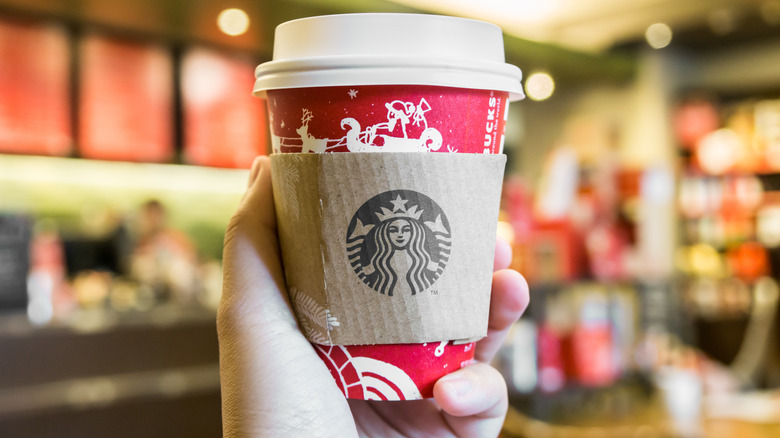 Person holding Starbucks drink in holiday cup