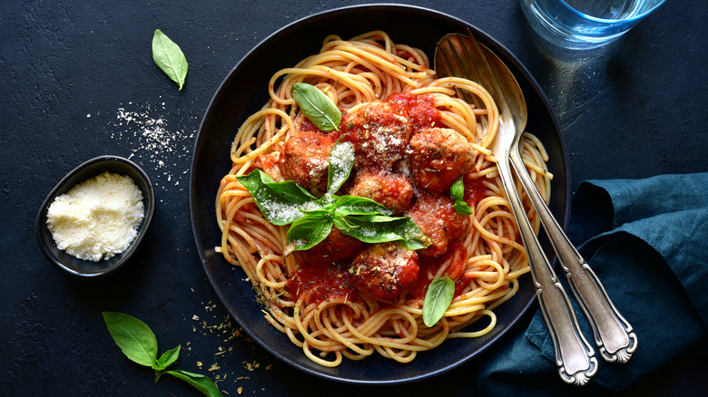 Spaghetti and meatballs on dark plate