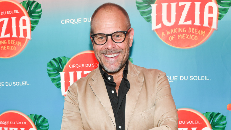 Alton Brown wearing s beige jacket