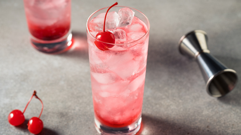 Shirley Temple with cherry on top and silver measuring tool