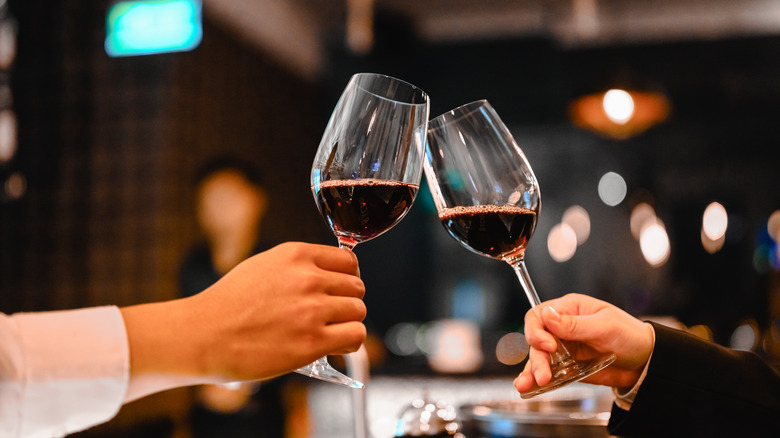 Two hands holding wine glasses