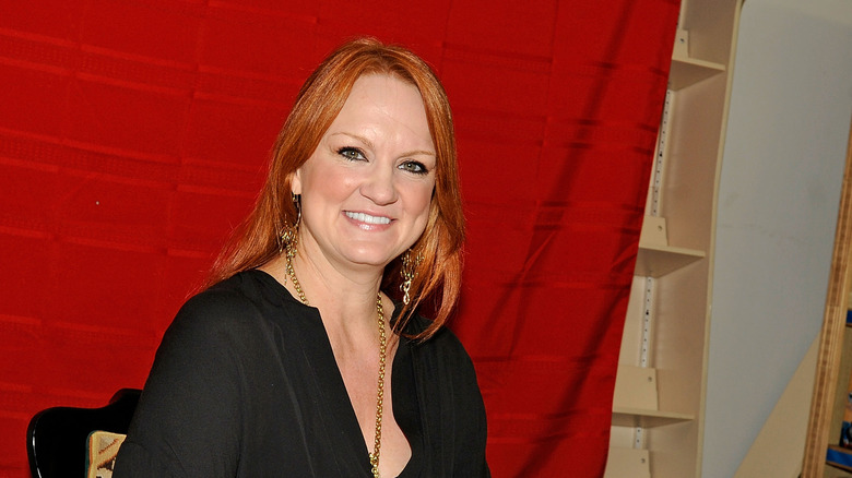 Ree Drummond smiling against red backdrop