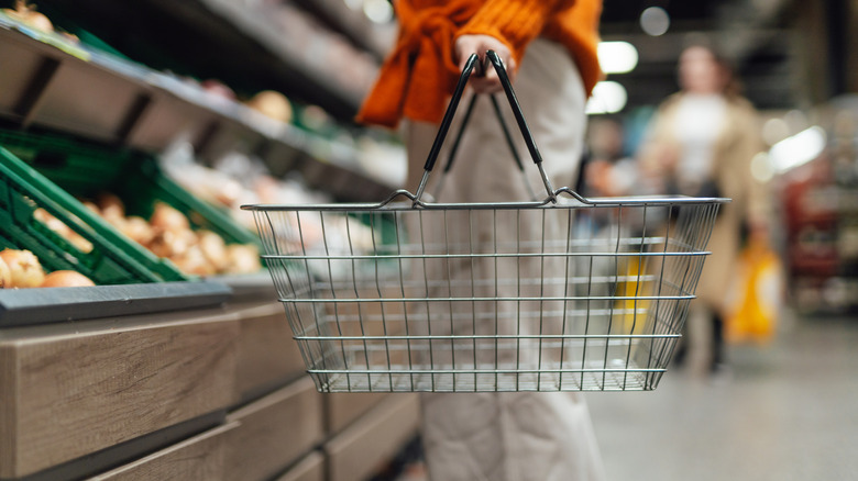 Hand holding shopping basket