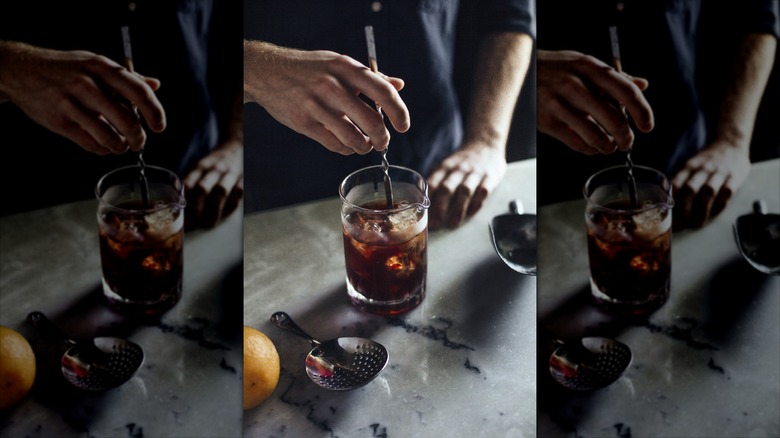 person stirring a cocktail with ice