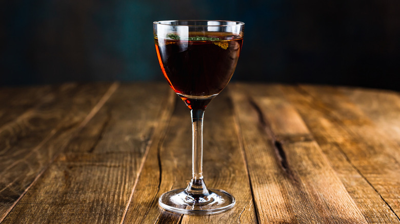 dark colored cocktail in a nick and nora glass