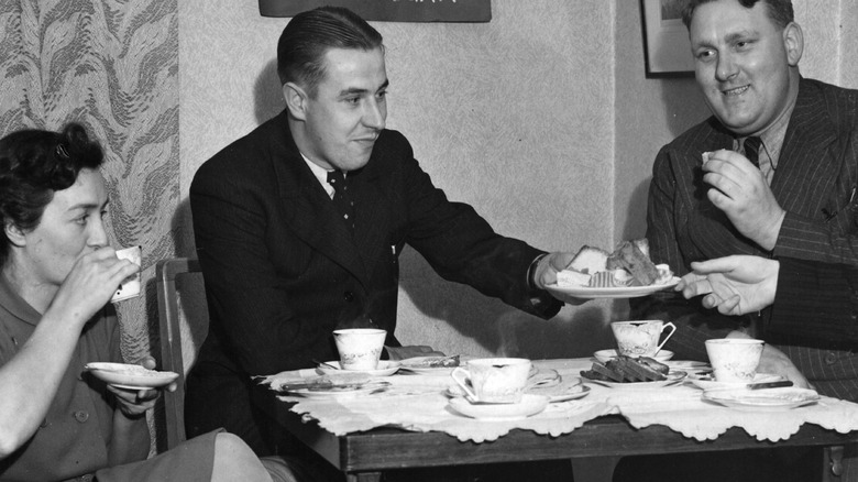 Black and white photo of people enjoying cake during WWII 