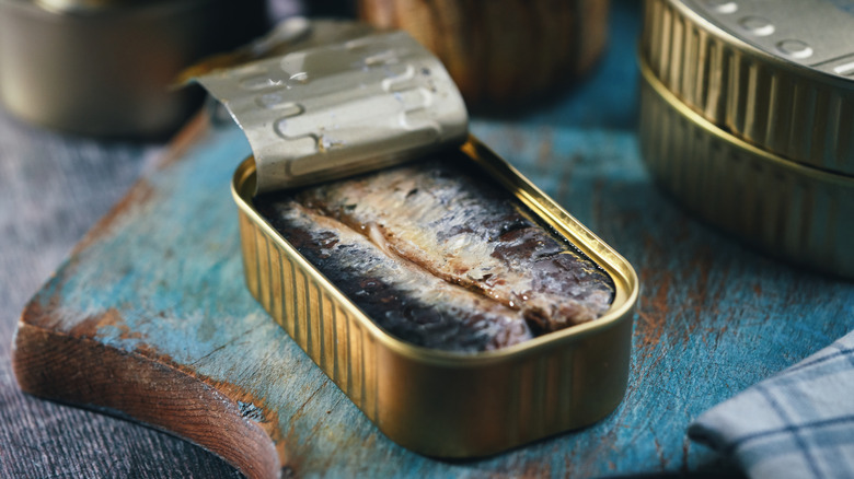 Canned sardines on cutting board