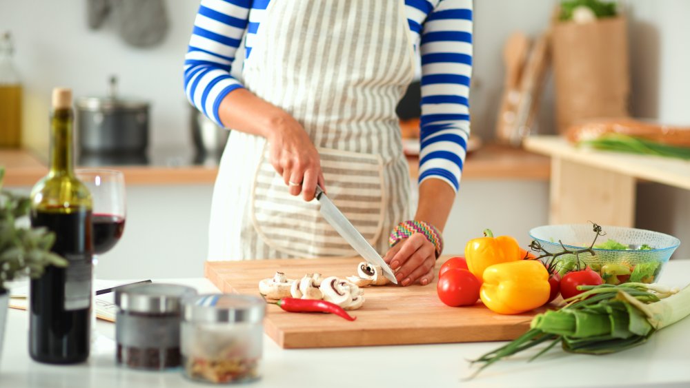 woman prepping vegetables to cook with red wine