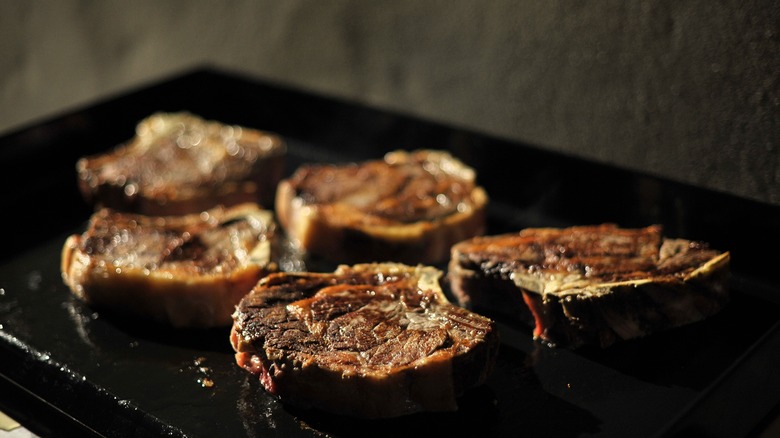 steak cooking on a plancha