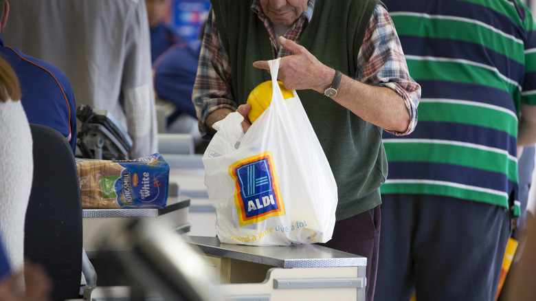 Customer bagging groceries at Aldi