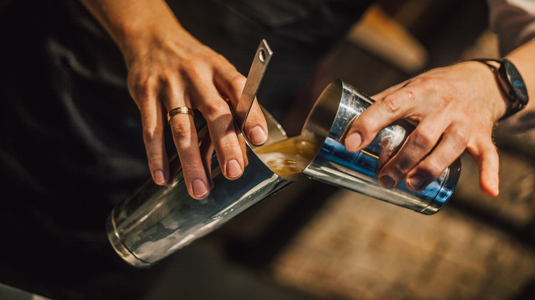 Bartender with mixing tins