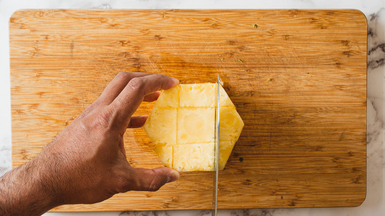 cutting a pineapple into rings