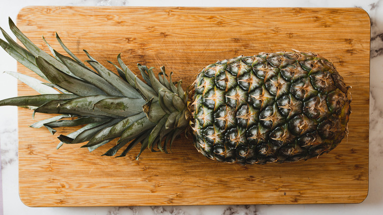 whole pineapple on cutting board