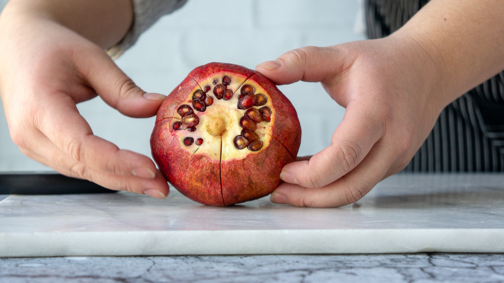 a pomegranate with 5 slices made along the sides