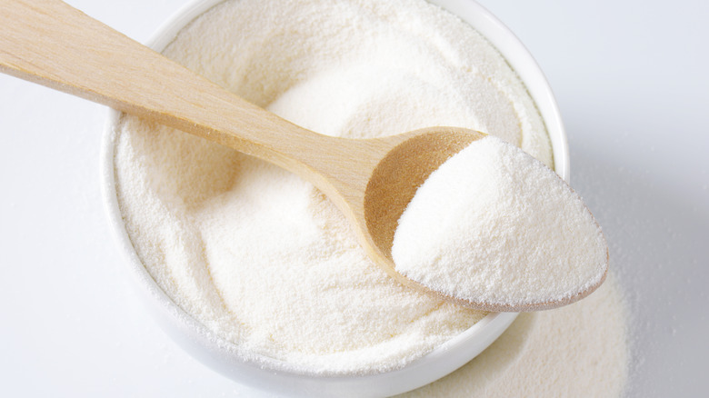 powdered milk on small wooden spoon