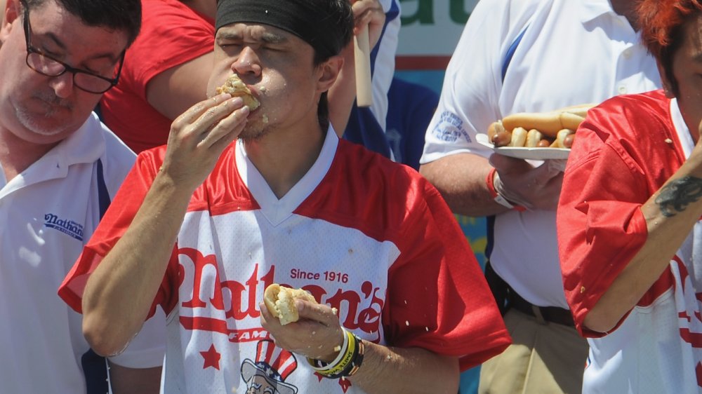 use both hands to eat hot dogs