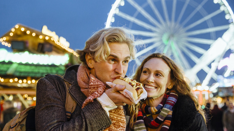 man eating hot dog at fair