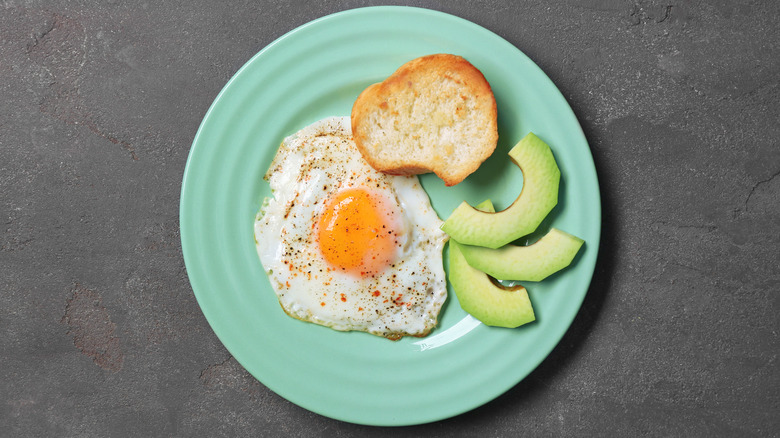 Over easy egg with toast and avocado