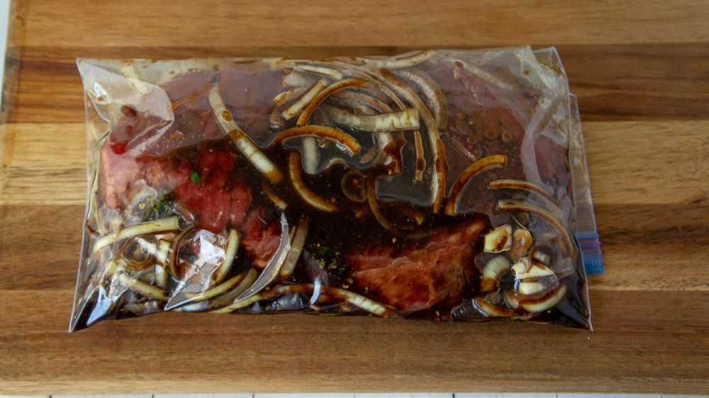 a steak in a zip top bag with marinade