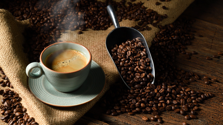 coffee in blue cup with coffee beans in scoop